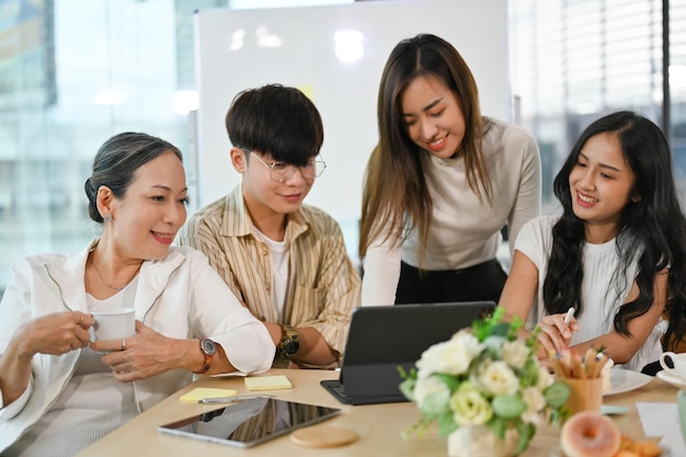 A group of cheerful Asian business people discussing and planning their project together