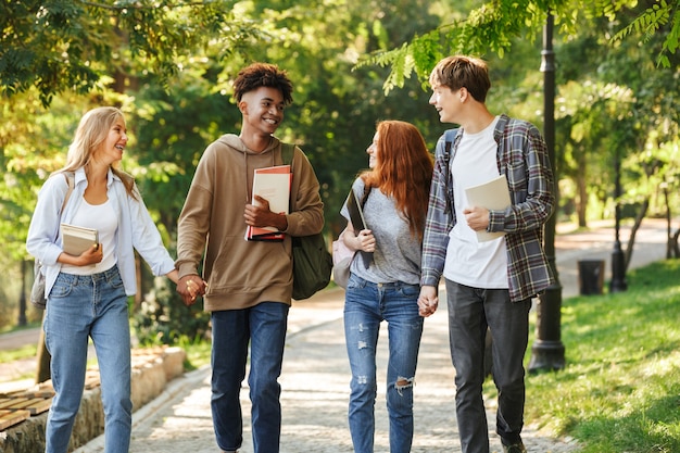 Photo group of cheerful students walking at the campus