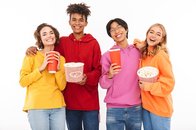 Group of cheerful teenagers isolated, watching a movie, eating popcorn