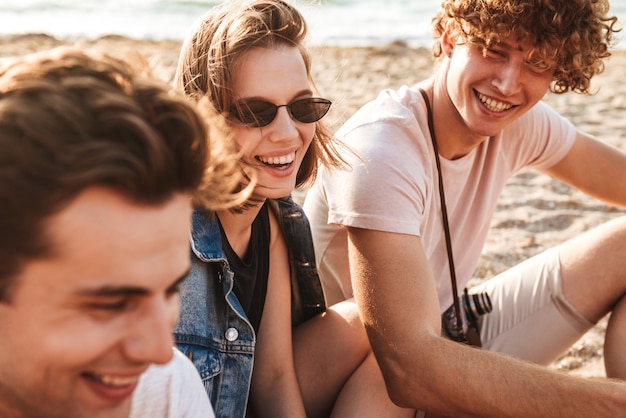 Group of cheerful young friends having fun time together at the beach