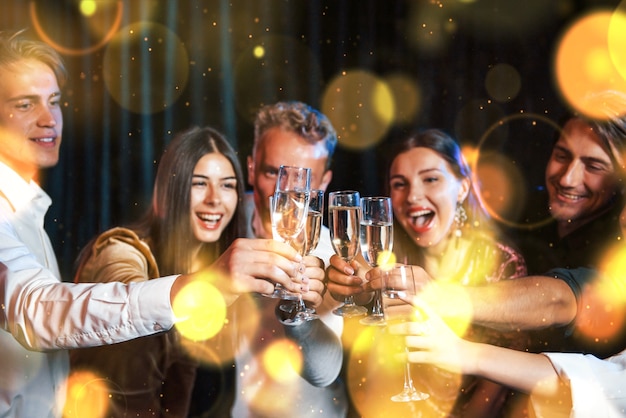 Group of cheerful young people have party and celebrating new year indoors.