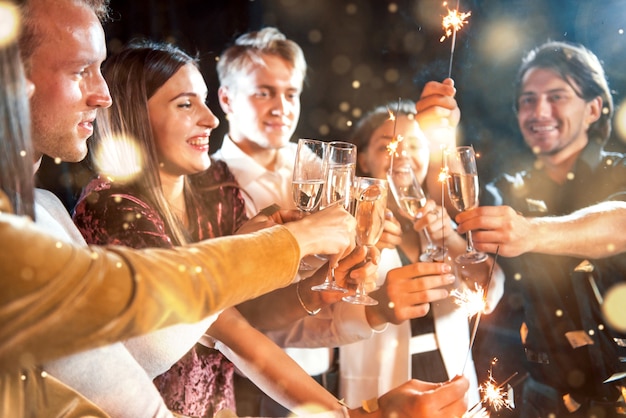 Un gruppo di giovani allegri fa festa e festeggia il nuovo anno al chiuso.