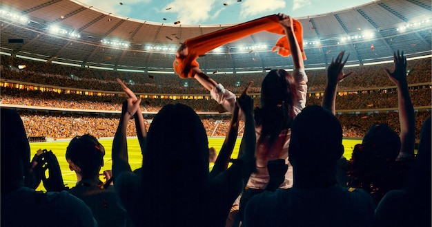 group of cheering fans watch a sport championship on stadium their team wins and everybody are celebrating this event people are dressed in casual cloth