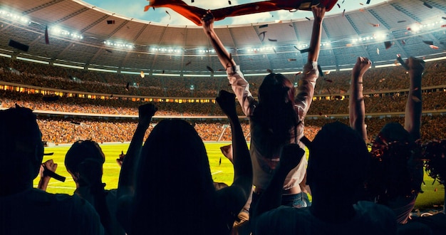 Group of cheering fans watch a sport championship on stadium Their team wins and everybody are celebrating this event People are dressed in casual cloth