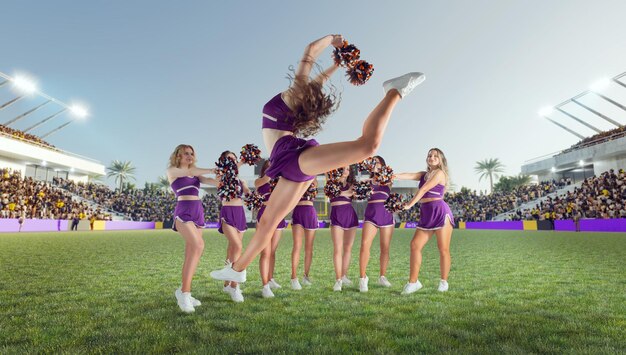 Foto gruppo di cheerleader in azione sullo stadio