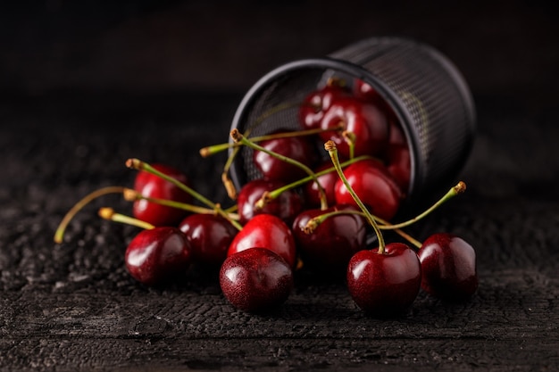 Gruppo di ciliegia su un tavolo di legno scuro. succose bacche di ciliegia fresca. primo piano di un gruppo di frutta