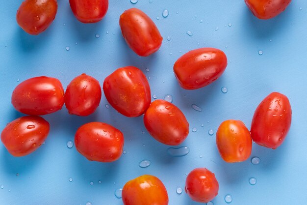 Photo group of cherry tomatoes isolated on blue background