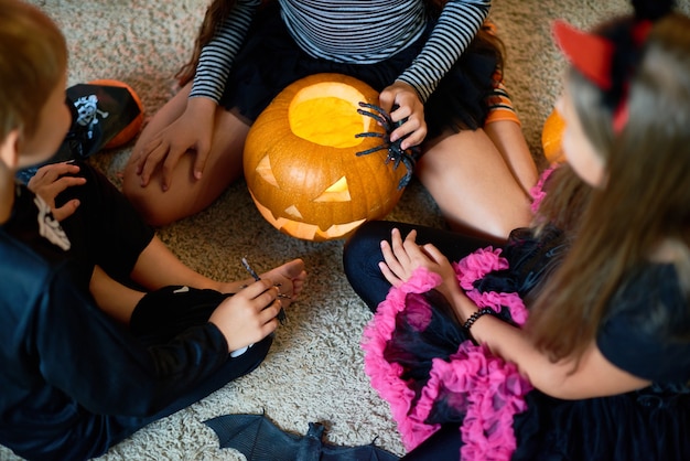 Photo group of children playing with pumpkin on halloween