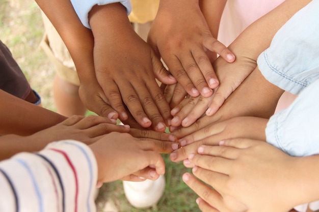 Gruppo di bambini che uniscono le mani