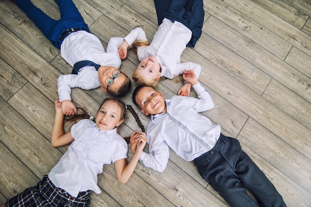 Group of children in school uniform cheerful and beautiful smile lying on the floor