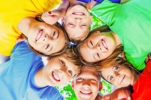 Photo group of children standing in circle and hugging, bottom view