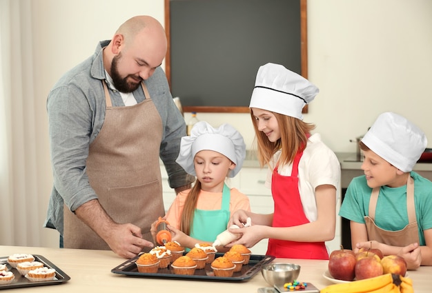 料理教室でデザートを準備する子供たちと先生のグループ