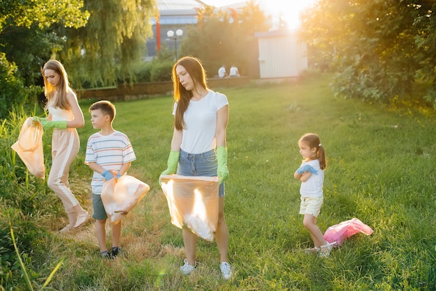 A group of children with their parents are engaged in garbage collection.

