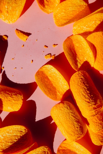 Group of chips on pink surface. Above view