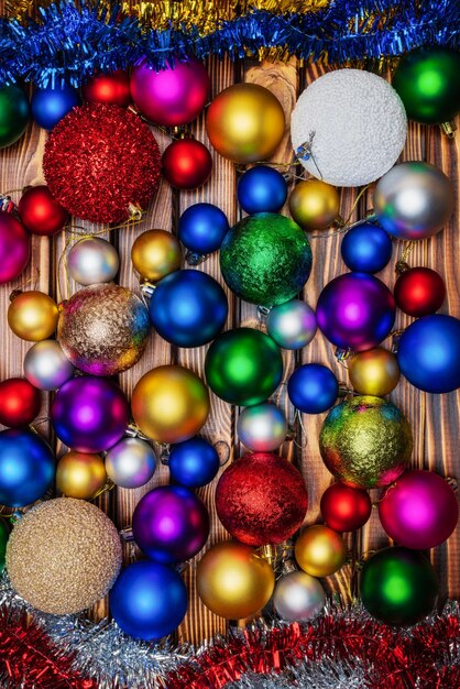 Group christmas balls spheres tinsel on wooden table background closeup happy new year decoration