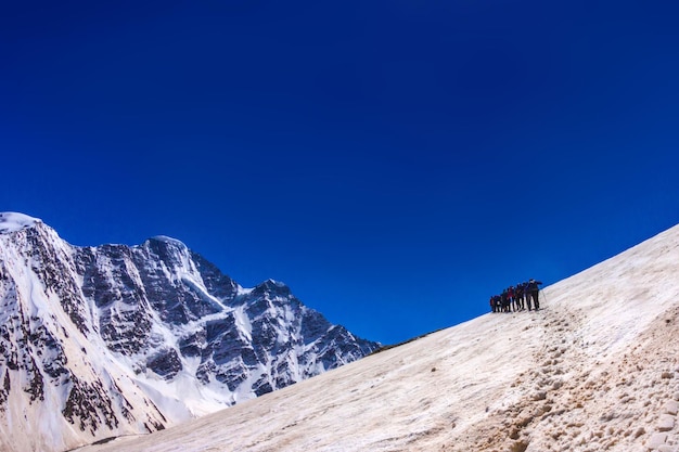 Photo a group of climbers each other in a chain go to the conquest of the top