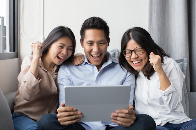 Group of colleague looking at digital tablet with happiness