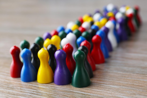 group of color pawns on wooden table unity concept