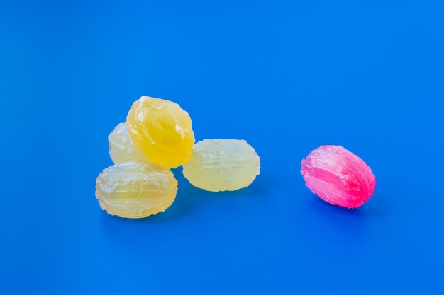 Group of Colorful Candies Scattered on blue background. Confectionery and sweets store concept. Stock photo.