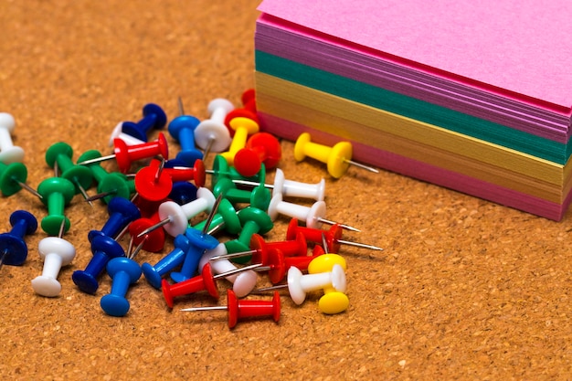 Group of colorful push pins on cork board