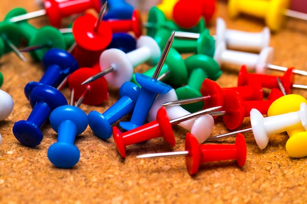 Group of colorful push pins on cork board