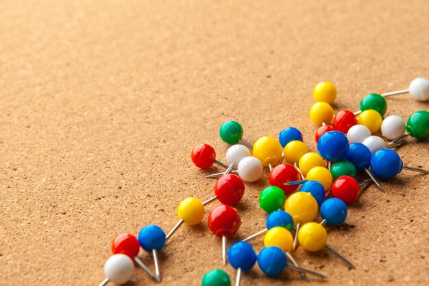 Group of colorful push pins on cork bulletin board