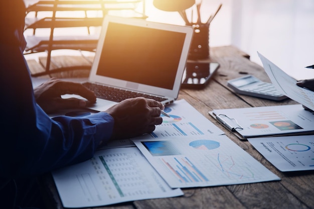 Group of confident business people point to graphs and charts to analyze market data balance sheet account net profit to plan new sales strategies to increase production capacity