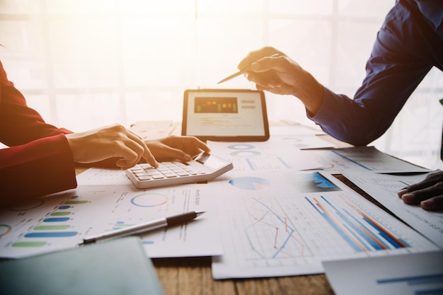 Group of confident business people point to graphs and charts to analyze market data balance sheet account net profit to plan new sales strategies to increase production capacity