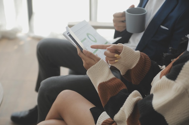 Group of confident business people point to graphs and charts to analyze market data balance sheet account net profit to plan new sales strategies to increase production capacity