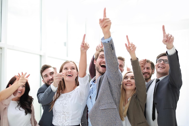 Group of confident young people pointing somewhere up