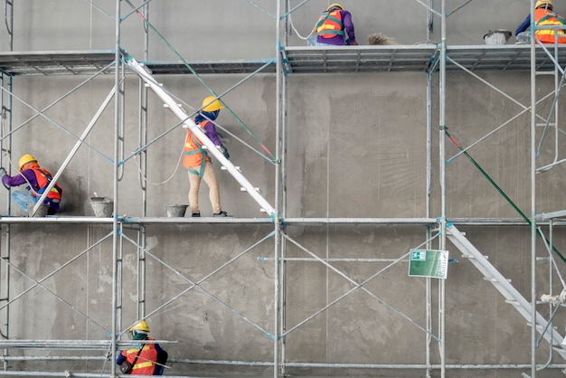 Group of construction worker plastering cement concrete water tank in construction area