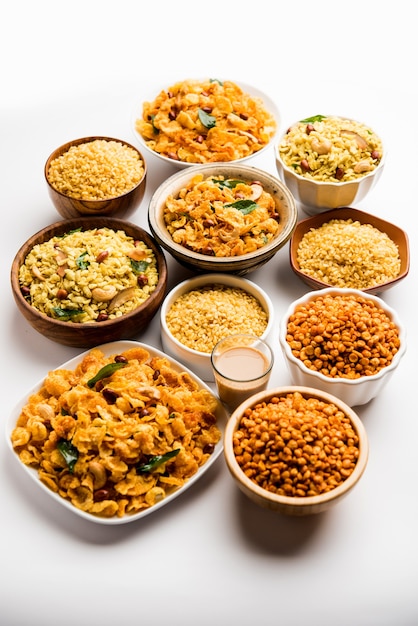 Photo group of cornflake and thick poha chivda or chiwda and chatpata masala chana and fried crispy moong dal, served in a bowl. selective focus