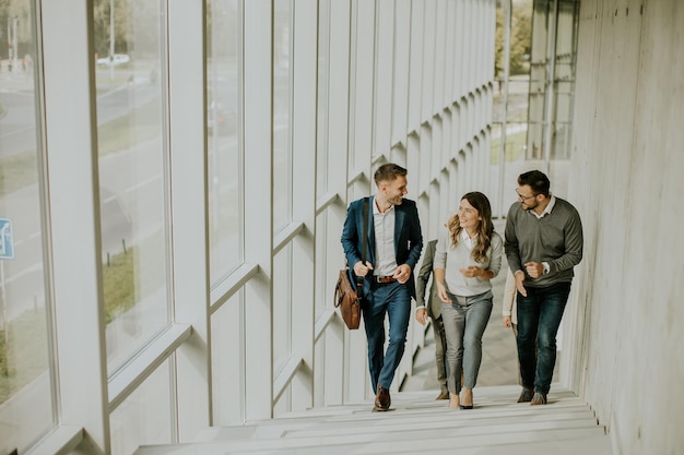 Group of corporate business professionals climbing at stairs in office corridor