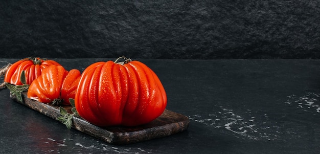 A group of Costoluto big tomatoes with oregano on a grey background space for text