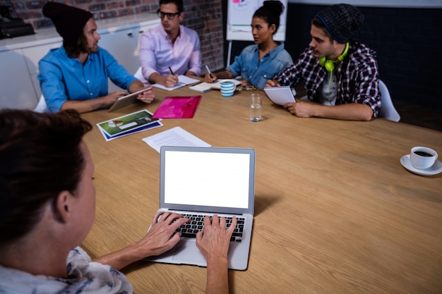 Group of coworkers during meeting and laptop