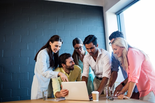 Group of coworkers watching a laptop