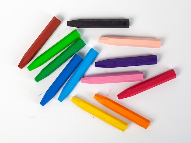 Foto gruppo di pastelli (matite) impilati su strumenti artistici bianchi