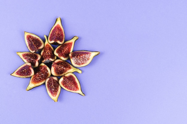 Group of cut figs on a blue background Copy space. Flat lay.