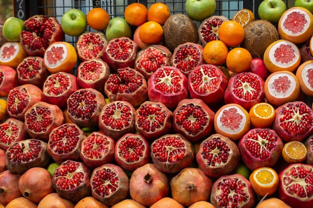 Group of cut red pomegranate fruit on display at market