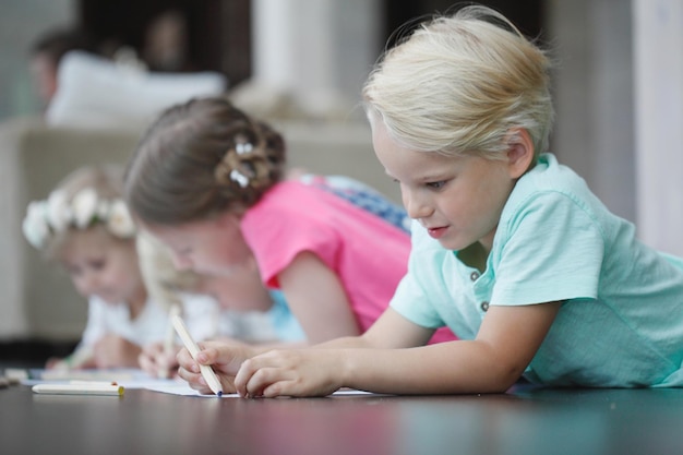 Group of cute children drawing with colorful pencils on floor