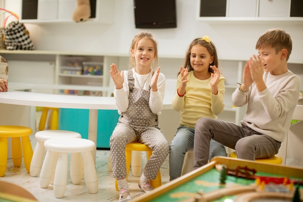 Group of cute kindergarten kid friends sitting and having fun