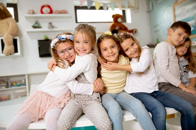 Group of cute kindergarten kid friends sitting and having fun