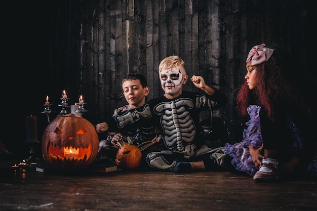 Group of cute multiracial kids in scary costumes during Halloween party in an old house. Halloween concept.