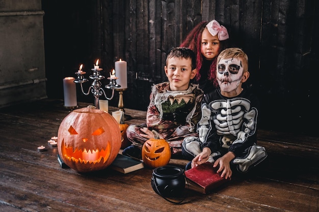 Group of cute multiracial kids in scary costumes during Halloween party in an old house. Halloween concept.