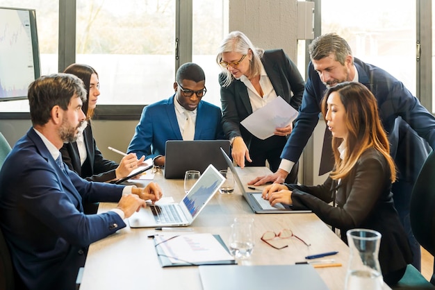 Group of diverse colleagues collaborating on project in conference room