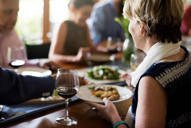 Un gruppo di amici diversi stanno cenando insieme