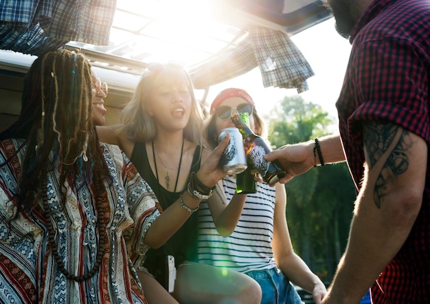 Foto gruppo di diversi amici che bevono insieme l'alcool delle birre sul viaggio stradale