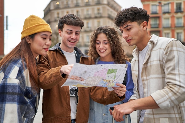 A group of diverse friends enjoying their Spain vacation happily selecting destinations on map