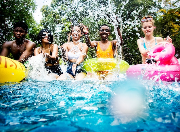 Group of diverse friends splashing water 