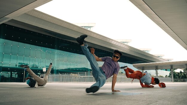 Photo group of diverse hipster or dancer doing head spin in front of mall sprightly